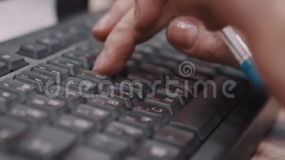 办公室职员用键盘打字和握笔的手指视频的预览图