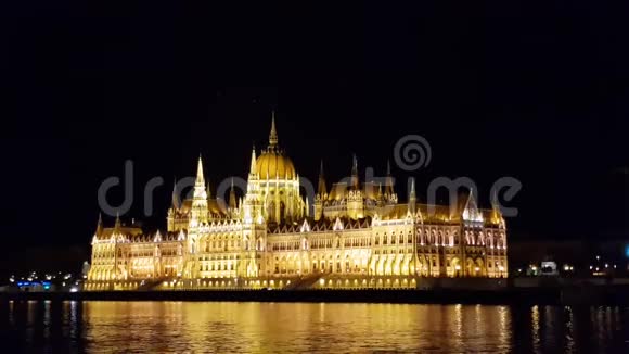 匈牙利国会大厦夜晚明亮而美丽的灯光鸟儿在上面盘旋视频的预览图