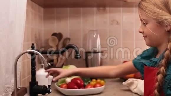 小女孩在厨房的水槽里洗蔬菜视频的预览图