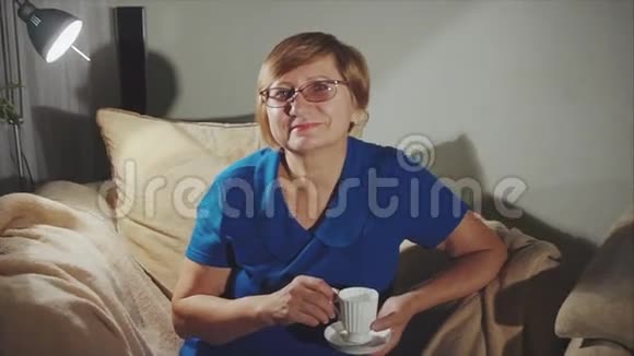 一位老年妇女坐在椅子上喝咖啡视频的预览图