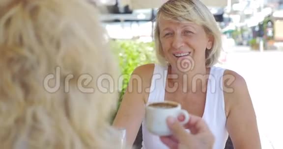 成熟的女性朋友在户外咖啡馆喝酒聊天视频的预览图