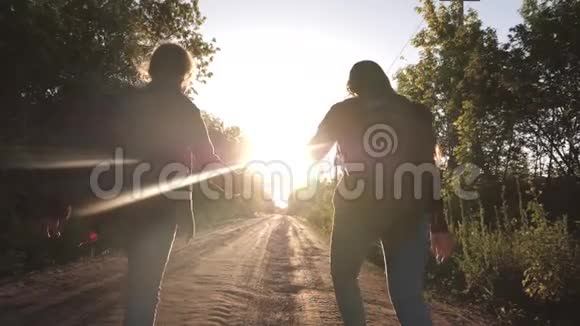 儿童旅行者徒步旅行者女孩带着背包的快乐女孩旅行者牵着双手在乡间小路上奔跑视频的预览图