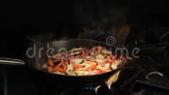 露天火焰上方的锅上的人为切菜视频的预览图