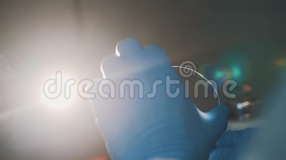 科学家用棉签在实验室用亮灯泡擦拭玻璃视频的预览图
