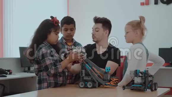 混合种族群体的学校儿童控制机器人机器与远程控制老师有创意的孩子视频的预览图