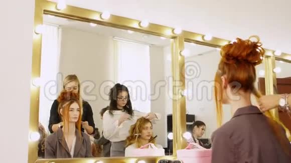 到目前为止女孩在镜子里看模特给她做一个漂亮的头发拍照视频的预览图