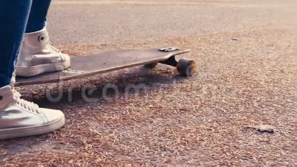 姜红头女人在日出时滑板滑板上的腿在夏季公园走向成功视频的预览图