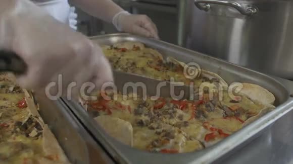 女厨师在厨房锅上用刀切砂锅视频的预览图