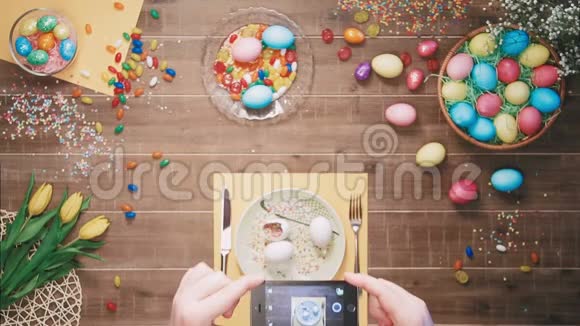 人们在用复活节彩蛋装饰的桌子上拍照复活节晚餐顶部视图视频的预览图