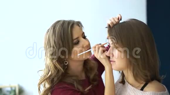 化妆师在重要活动前为女孩化妆眉毛视频的预览图