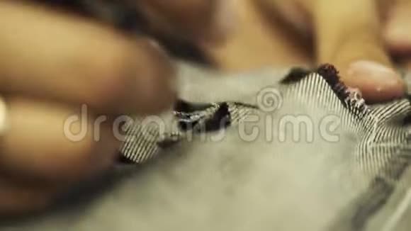 男式的手用剪针在牛仔牛仔裤上打眼泪视频的预览图