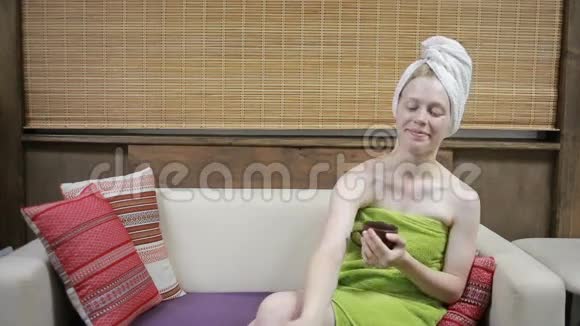 沙发上的女人用淋浴毛巾喝茶视频的预览图