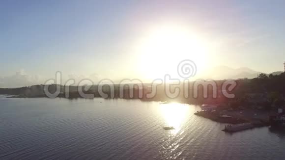 太阳升起在沿湖岸边建造的沿海定居点上飞行员视频的预览图