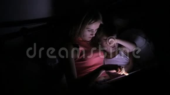 女儿在床上玩平板电脑视频的预览图
