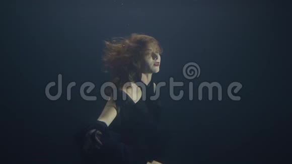 有魅力的女人在黑暗的游泳池下游泳同时拍摄视频视频的预览图