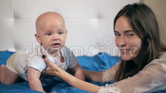 家庭孩子和父母的概念快乐的母亲亲吻微笑的婴儿视频的预览图