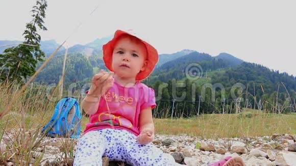 一个小孩子坐在炎热的夏天的山上全高清1920x1080视频的预览图