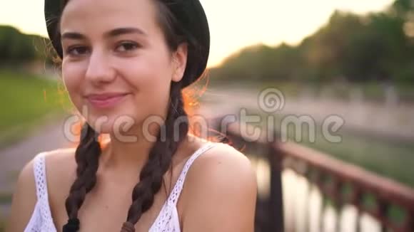 户外服装时尚帽子中年轻微笑女孩的肖像视频的预览图