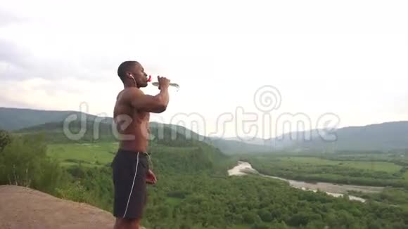户外运动训练后全身饮水的非裔美国人肌肉男的侧视图视频的预览图