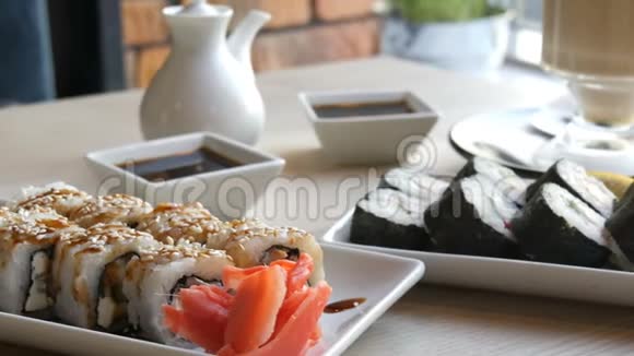 两套寿司卷在一个时尚装饰精美的咖啡馆在寿司旁边的桌子上有日本料理视频的预览图