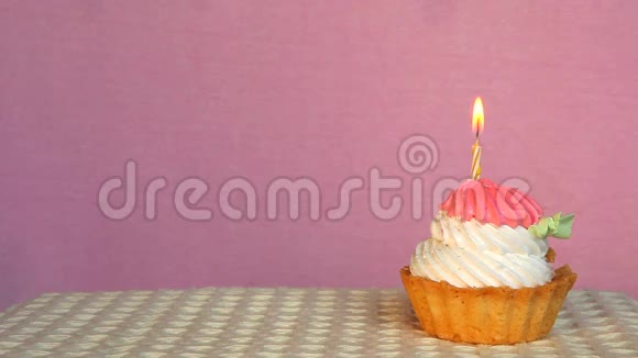 带有粉色背景和复印空间的燃烧蜡烛的生日蛋糕视频的预览图