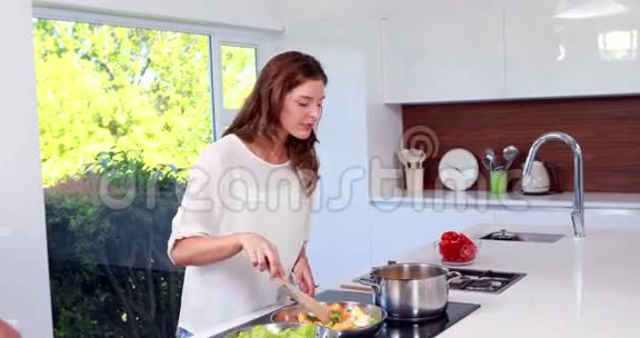 幸福的男人在妻子做饭的时候伸手接她视频的预览图