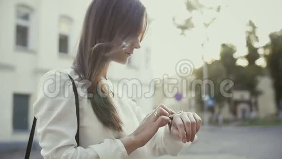 女人用智能手表站在老城区慢潮视频的预览图