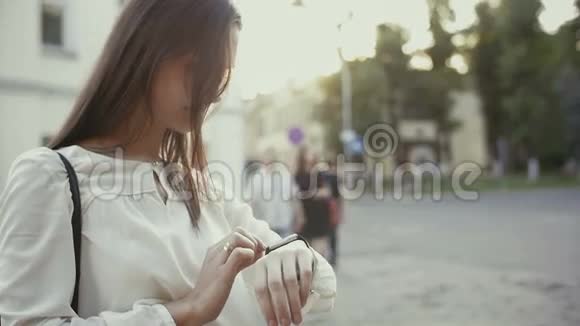 女人用智能手表站在老城区慢潮视频的预览图
