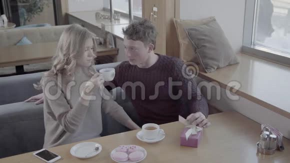 从顶部看一个男人和一个女孩坐在靠近窗户的咖啡馆的桌子旁视频的预览图