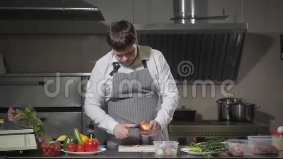 年轻的厨师在一个白色的特写上切洋葱在餐厅厨房做饭视频的预览图