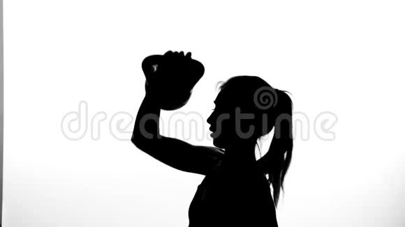 在一个白色的背景上一个阴影一个黑色的轮廓一个女性人物做锻炼与重量使用视频的预览图