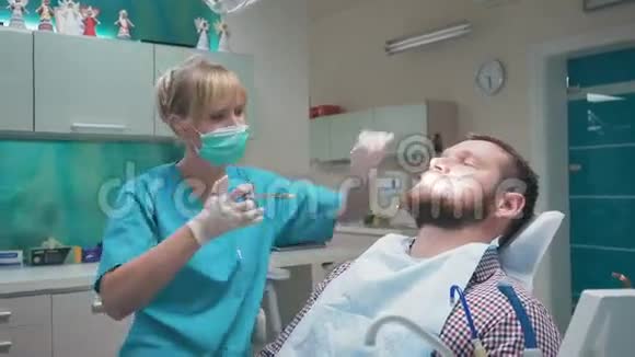 牙科医生给牙龈注射麻醉剂并与病人交谈视频的预览图