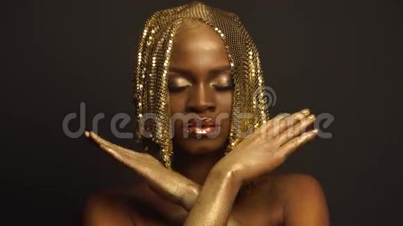 美国黑人女性模特的超现实时尚肖像带有金色光泽的头饰创意时尚概念黑色视频的预览图