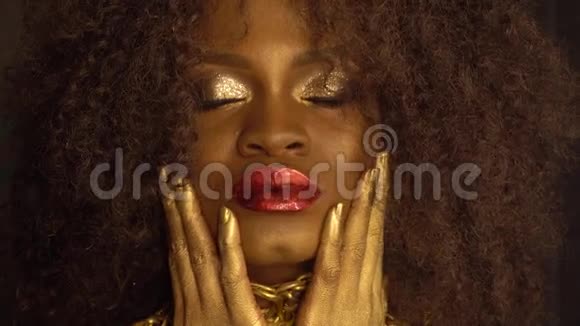 年轻的非裔美国女性模特的特写时尚肖像金色光泽的妆容面子艺术黑人工作室视频的预览图