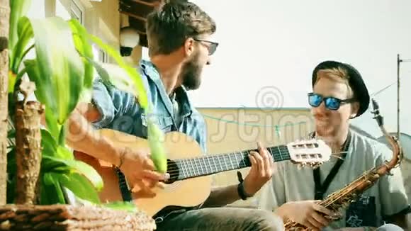 一个人在弹吉他而他的朋友用萨克斯管摇摆着视频的预览图