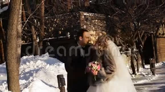新娘和新郎在下雪的路上视频的预览图