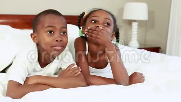 可爱的兄弟姐妹在床上窃窃私语视频的预览图