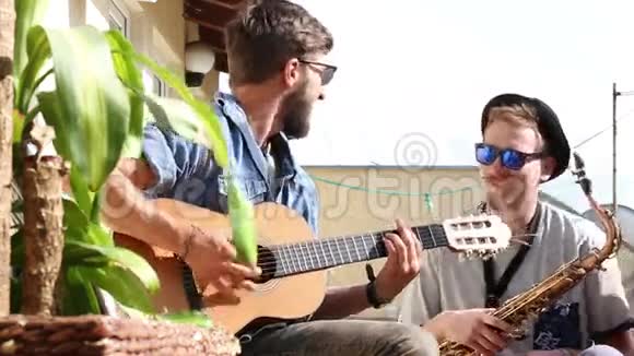 一个人在弹吉他而他的朋友用萨克斯管摇摆着视频的预览图