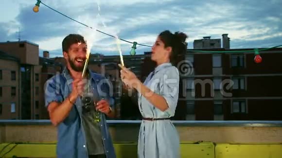 情侣们玩着烟火蜡烛和香槟挥手视频的预览图