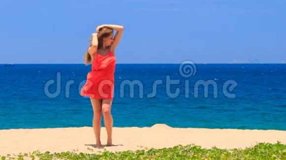 在沙滩上跳舞的金发姑娘摇着长发视频的预览图
