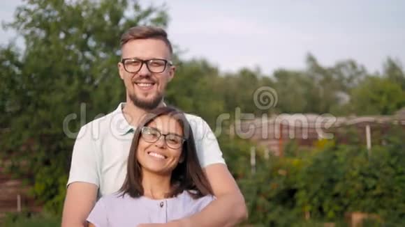 花园里一对恩爱幸福的年轻夫妇的画像男人拥抱妻子视频的预览图