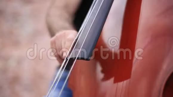人用手指特写弹大提琴录像人在海边玩大提琴视频的预览图