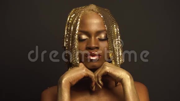 超现实主义神秘黑人非洲裔美国女性模特的大特写肖像金色的脸艺术和光滑的嘴唇视频的预览图
