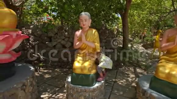 小女孩在寺庙公园坐佛雕像视频的预览图