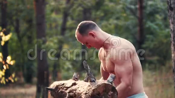 肌肉发达的人举起一根沉重的木头视频的预览图