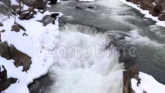 空中拍摄的冬季白色瀑布与雪岩空中拍摄大瀑布国家公园视频的预览图