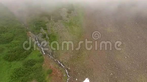 全景空中观锦绣瀑布山溪飞过石头和雪视频的预览图