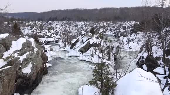 空中拍摄的冬季白色瀑布与雪岩大瀑布国家公园视频的预览图