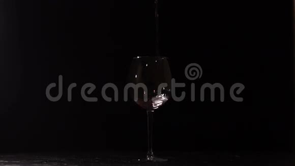 在黑暗中空的透明玻璃杯里装满了红酒视频的预览图