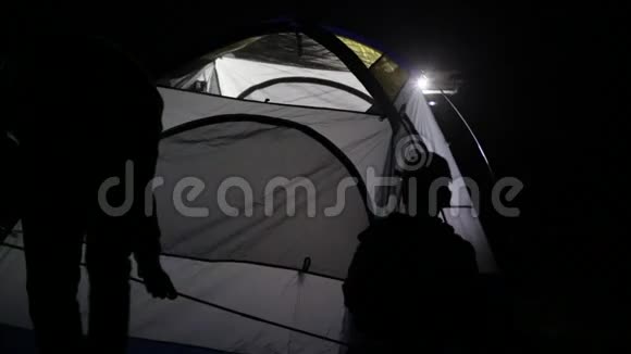 两名成年男子和儿童从越野车上搭帐篷的夜间镜头视频的预览图